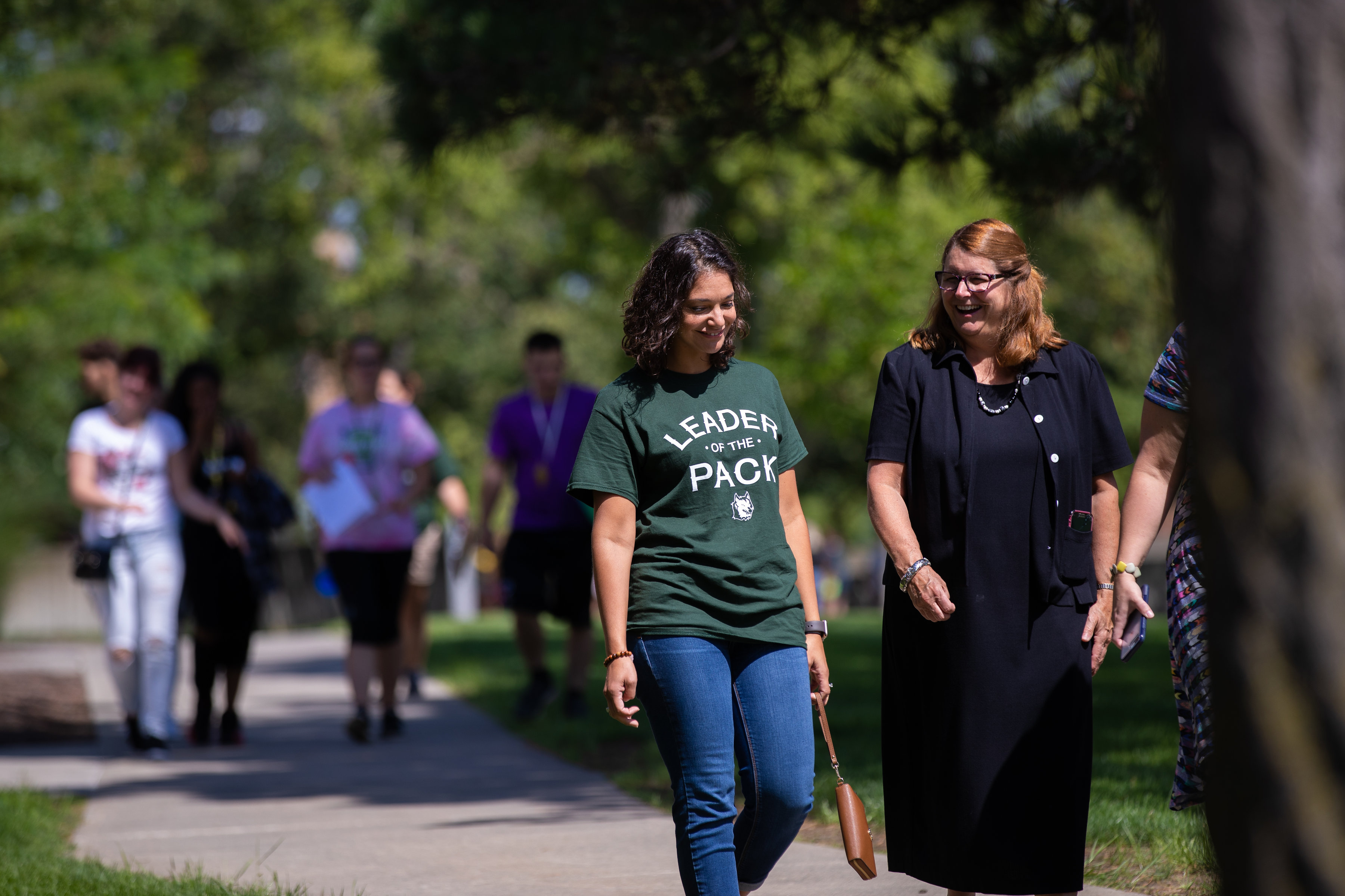 Dr. Anne Weed walking through campus with student