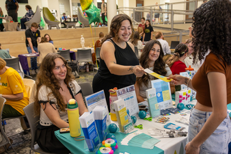 Students smiling with a facilitator at a wellness event.
